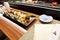 Sushi in Japanese Food Restaurant â€“ Kitchen Serving Background, Plate with Soy Sauce, Row of Nigiri and Rolls with Wasabi