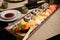 Sushi in Japanese Food Restaurant â€“ Plate with Soy Sauce, Chopsticks, Row of Nigiri and Rolls with Wasabi, Red Caviar