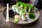 Sushi maki rolls with cucumber, avocado, tomato, creamy cheese, chuka wakame on a plate with chopsticks, soy sauce