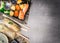 Sushi menu with summer rolls, nigiri and soy sauce on gray stone background, top view