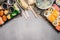 Sushi menu with summer rolls in rice paper wrappers and miso soup on gray on gray stone background, top view, border