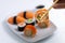 Sushi plate on white background. Makizushi. Delicious sushi rolls on white plate with chopsticks and wasabi. Maki