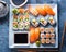 Sushi platter with different types of sushi rolls and sashimi on a white plate, in a top view