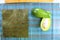 Sushi preparation in the kitchen, fresh ingredients green avocado cut in half with a seaweed and white cooked rice on a wooden cut