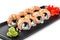 Sushi Roll - Maki Sushi made of grilled salmon, black caviar and cream cheese on black plate isolated over white background