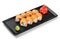 Sushi Roll - Maki Sushi made of salmon, avocado and cream cheese on black plate isolated over white background.