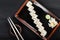 Sushi Roll - Maki Sushi made of salmon, orange, avocado and cream cheese on dark wooden background.