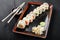 Sushi Roll - Maki Sushi made of salmon, orange, avocado and cream cheese on dark wooden background.