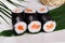 Sushi roll salmon chives mini kappa maki in the still life on a tropical leaves