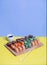 Sushi roll with soy sauce and chopsticks on a wooden stand on a bright yellow-blue background. Sushi menu
