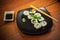 Sushi roll with tuna and cucumber on black plate