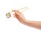 Sushi roll with wooden chopsticks in female hand