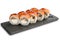 Sushi Rolls with eel and salmon and Cream Cheese inside on black slate or stone shale surface isolated