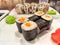 Sushi rolls with fresh ingredients served on a platter. Japanese Sushi Rolls on White Plate With Ginger Garnish. Blurred