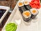 Sushi rolls with fresh ingredients served on a platter. Japanese Sushi Rolls on White Plate With Ginger Garnish. Blurred