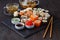 Sushi rolls, maki, nigiri Set served for two on black stone slate on dark background