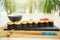 Sushi rolls with salmon and hot tea ceremony on black wooden table. Fried hot Roll with salmon, avocado, cucumber