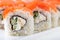 Sushi with salmon on a white plate with wasabi, ginger, soy, chopsticks on a white background