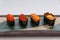 Sushi Set Include Tobiko, Ikura, Sea Urchin and Ikura, Urchin and Quail Egg Yolk Served on Leaf on Stone Plate