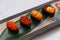 Sushi Set Include Tobiko, Ikura, Sea Urchin and Ikura, Urchin and Quail Egg Yolk Served on Leaf on Stone Plate