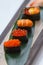 Sushi Set Include Tobiko, Ikura, Sea Urchin and Ikura, Urchin and Quail Egg Yolk Served on Leaf on Stone Plate