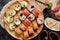Sushi set with Philadelphia, roll with avocado and roll with tuna on round wooden board on dark background. Close-up
