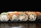 Sushi set Philadelphia roll with king prawn, smoked eel, salmon and cream cheese on a black background. Traditional