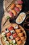 Sushi set with roll Philadelphia, roll with avocado and roll with tuna on round wooden board on dark background. Top