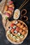 Sushi set with roll Philadelphia, roll with avocado and roll with tuna on round wooden board on dark background. Top