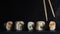 sushi set in a row on a stone board with chopsticks on a dark plaster background. artistic moody food photo with copy space