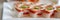 Sushis on plate at japanese restaurant banner panoramic background. Closeup of Aburi Oshi sushi, seared salmon box