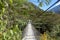 Suspended bridge hanging above the Santa Teresa River in green lush valley. Trek to Machu Picchu, Peru