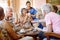 The suspense keeps the game exciting. Shot of a group of happy seniors playing a card game in their retirement home