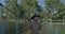 A Suspension Bridge is crossed by a man. A young man goes across a park bridge