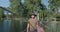 A Suspension Bridge is crossed by a man. A young man goes across a park bridge