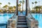 A suspension bridge hanging over a hotel pool leading between the