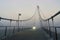 Suspension bridge at Herrenkrug near Magdeburg with light of a cyclist in fog