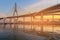 Suspension bridge over watergate during sunset