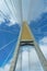 Suspension bridge pillar and sling paning up to the blue sky