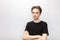 Suspicious young man with crossed arms studio shot on gray background