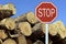 Sustainability concept: traffic stop sign in front of fallen trees