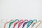 Sustainable responsible consumption concept. Many bright multi-colored velvet pop color hangers on white background. Store, sale,