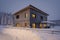 Sustainable solar thermal heated house with collector and wood facade in the evening in winter