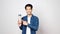 Sustainable and zero waste concept Young asian man smiling and holding reusable bottle looking at camera while standing on