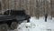 SUV 6x6 overcomes off-road in the winter forest