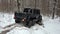 SUV 6x6 overcomes off-road in the winter forest. Jeeping