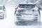 SUV car driving on snowy slippery road inside the forest, having registration number insivisible due to snow