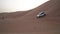 SUV descends from a high dune in the Rub al Khali desert stock footage video