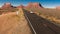 SUV drives toward Monument Valley on Utah/Arizona border, American southwest