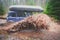 Suv offroad 4wd car rides through muddy puddle, off-road track road, with a big splash, during a jeeping competition